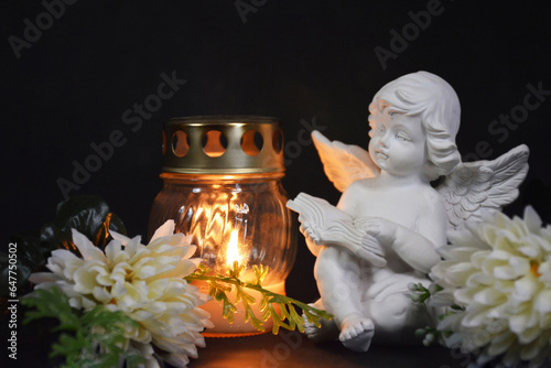 Canvastavla Sympathy card with an angel figurine, votive candle and flowers on black backgro