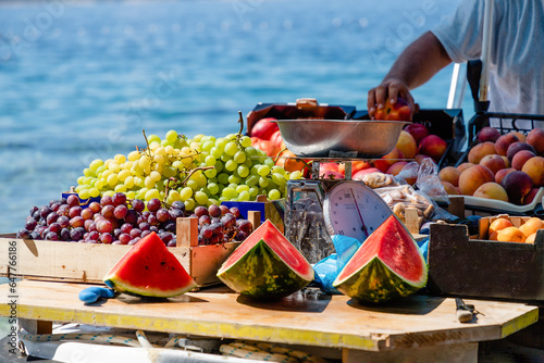 Watermelons, green and purple grapes, peaches in a boat in Croatia