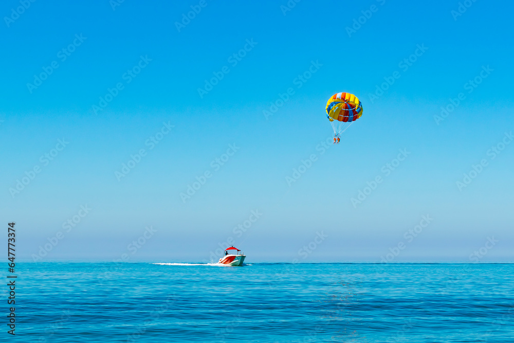 parasailing. ride on a colored parachute attached to a motor boat. place for text parasailing. ride on a colored parachute attached to a motor boat. place for text