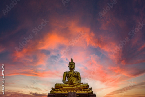 Golden Buddha statue with beautiful sunset for background