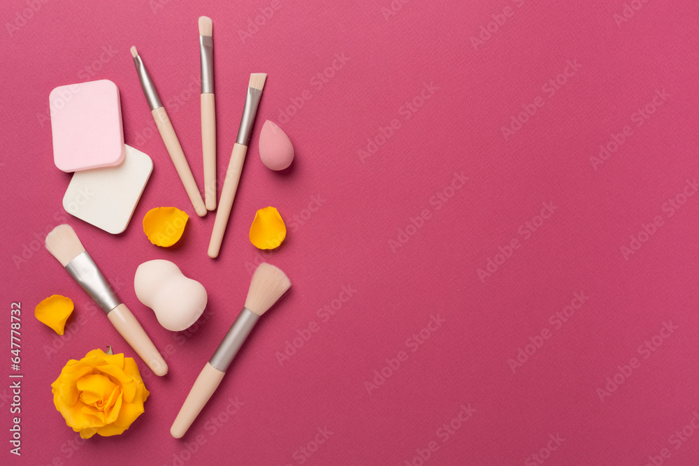 Makeup brushes and sponges on color background, top view Makeup brushes and sponges on color background, top view