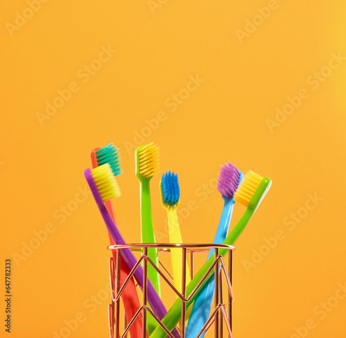 A lot of colorful toothbrushes standing in a stand. Cleaning the teeth and healthy.