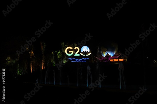 Symbol of G 20 summit displayed in a park with colors  of the Indian flag on trees nearby, india