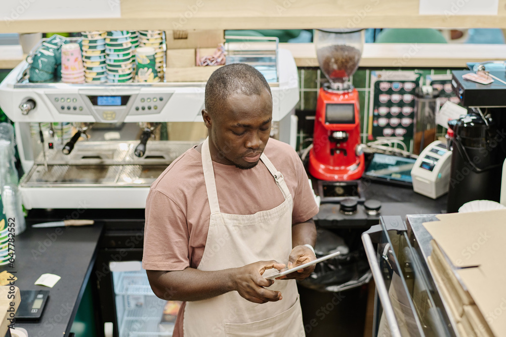 African American barman working online on digital tablet African American barman working online on digital tablet