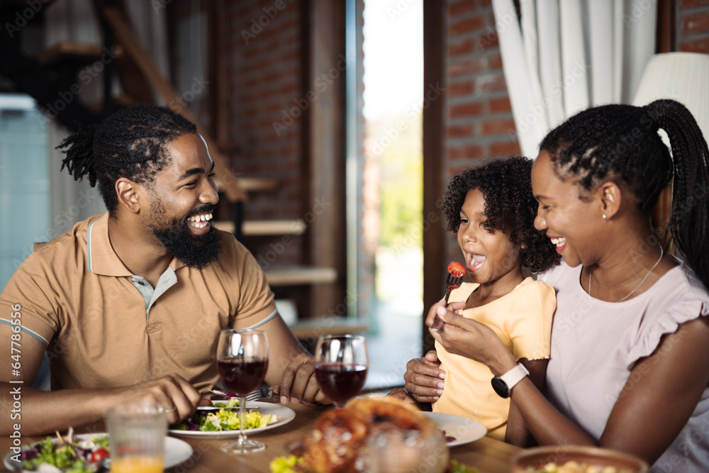 Happy black family enjoying in lunch time at dining room