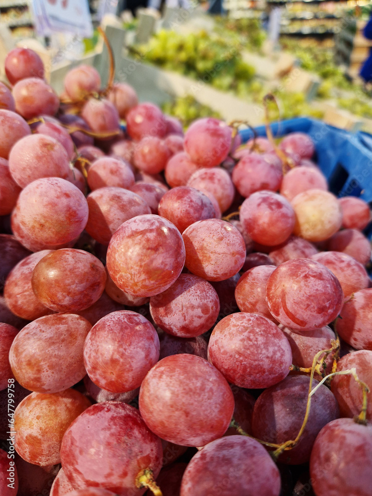 Bunches of grapes in a box in a supermarket. Pink grapes, close-up. Harvest of juicy pink grapes Bunches of grapes in a box in a supermarket. Pink grapes, close-up. Harvest of juicy pink grapes