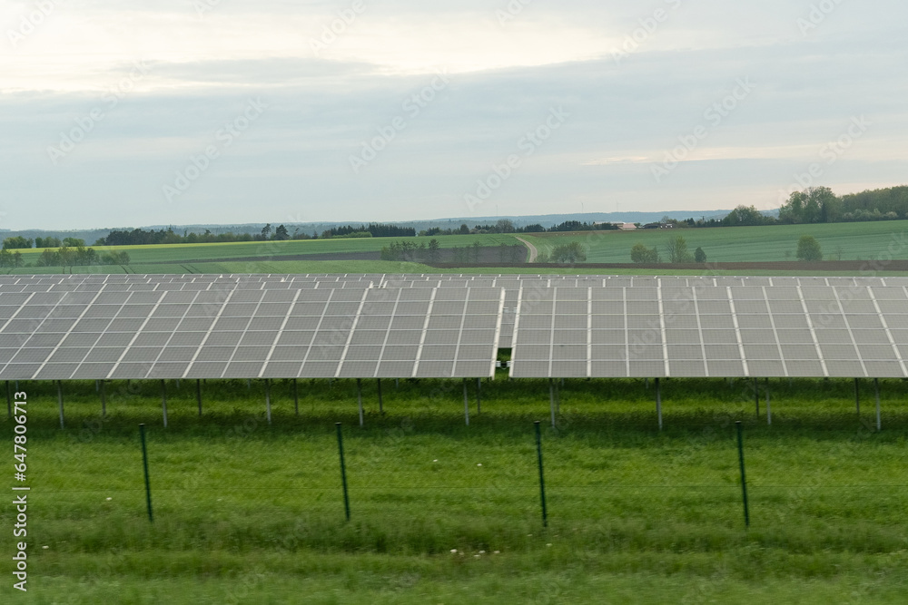 Solar panels of a power plant on a green field