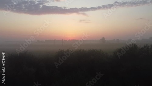 The early morning with sunrise among the forest, fields and fog