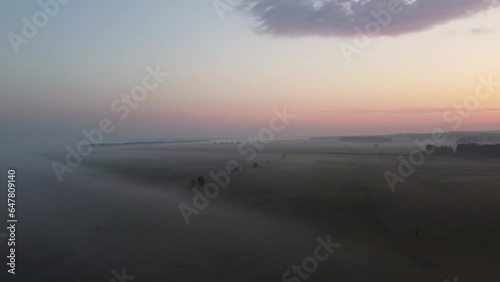 The early morning with sunrise among the forest, fields, and fog. You may see horizon and landscape from the higher point of view.