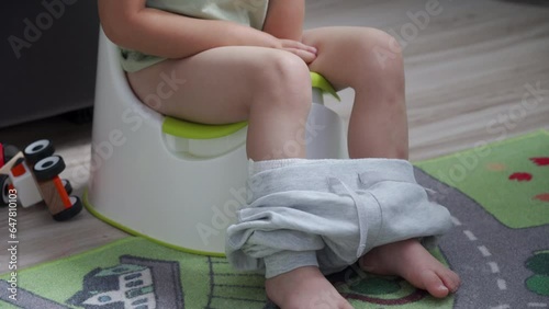 toddler child little boy sitting on a potty in the room