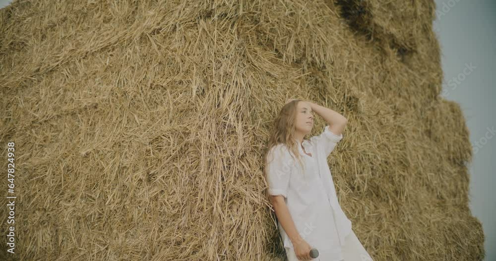 Thoughtful Woman Leaning On Dry Stack Of Hay Thoughtful Woman Leaning On Dry Stack Of Hay