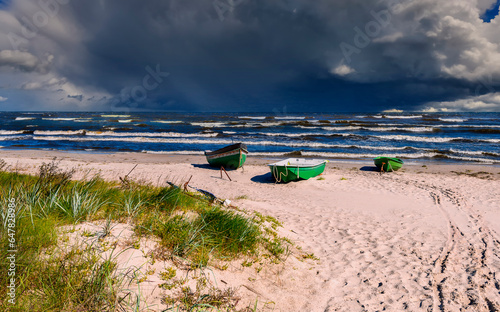 Coastal landscape in autumn with fishing boats anchored at sandy beach of the...