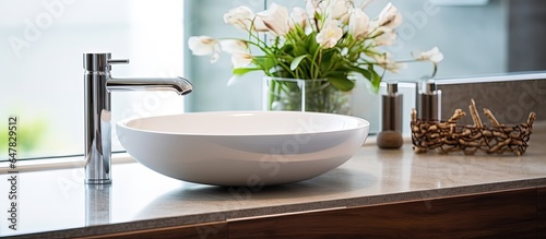 Modern bathroom with mirror and wooden stand supporting shiny steel faucet and oval washbasin