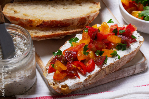 Bruschetta from homemade bread with cottage cheese and sprat pate and tomatoes on a wooden background. Rustic style.