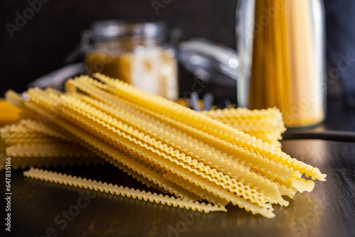 Mafaldine pasta. Uncooked italian pasta on black table.