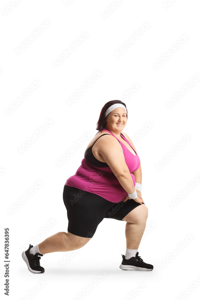 Fototapeta premium Corpulent woman in sportswear stretching knees