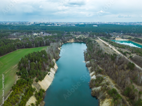 Fototapeta Naklejka Na Ścianę i Meble -  Aerial photography of a flooded sand pit from a drone. A sand mine for cement production. Beautiful industrial aeroplane. Mining industry. Mining with the help of a drone and modern technologies.