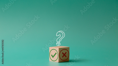 Tick mark and cross mark on a wooden cube. the decision between Yes or No choice symbol for approval or rejection. Change or choose a method or business strategy concept. Copy space with question mark