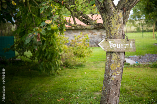 Garden view with an arrow welcoming sign "Fournil", bakery, In France. Background or wallpaper.