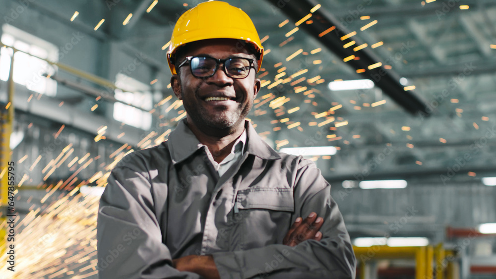 African-American employee wearing casque and glasses is smiling and looking at camera. Worker looks joyful with arms crossed. Multiplicity of production professions. African-American employee wearing casque and glasses is smiling and looking at camera. Worker looks joyful with arms crossed. Multiplicity of production professions.