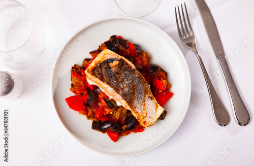 Tasty grilled salmon with garnish of braised vegetables on plate