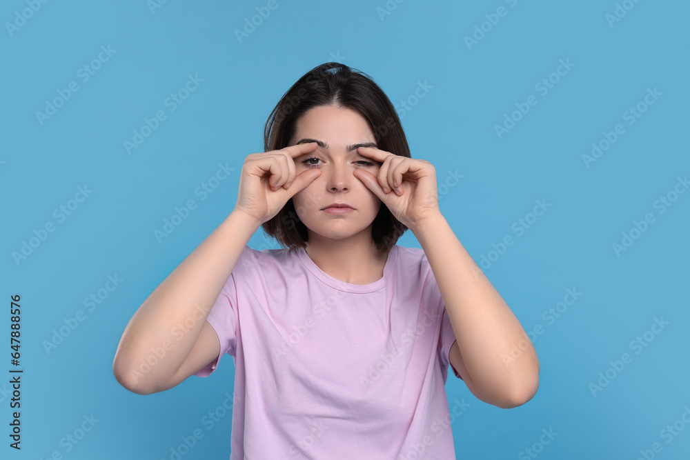 Sleepy young woman on light blue background. Insomnia problem Sleepy young woman on light blue background. Insomnia problem