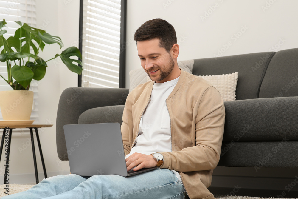 Man working with laptop on floor at home Man working with laptop on floor at home