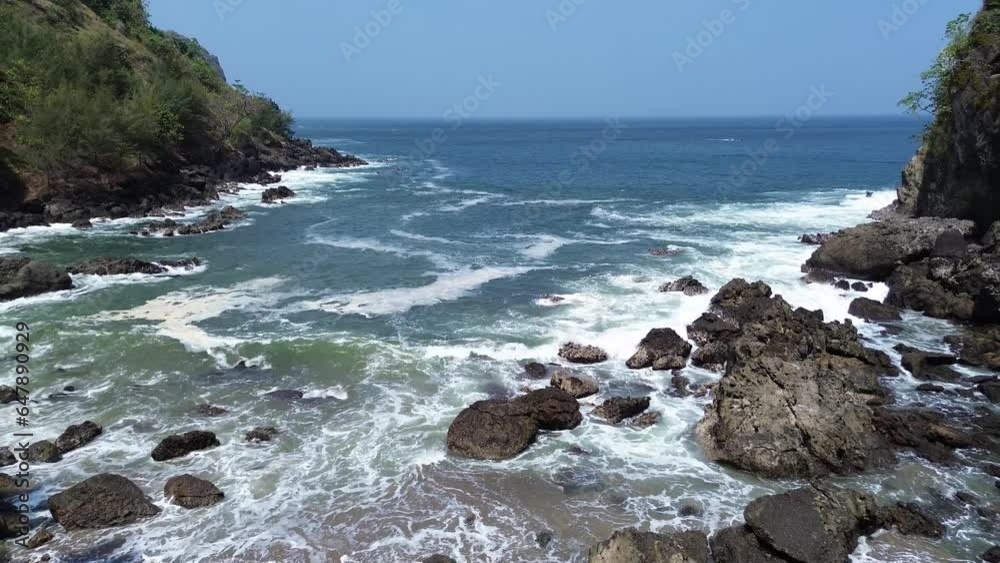 Bird eye view Menganti Beach Kebumen Central Java Indonesia, Beach with beautiful sea and waves with cliffs and trees on the edge Bird eye view Menganti Beach Kebumen Central Java Indonesia, Beach with beautiful sea and waves with cliffs and trees on the edge