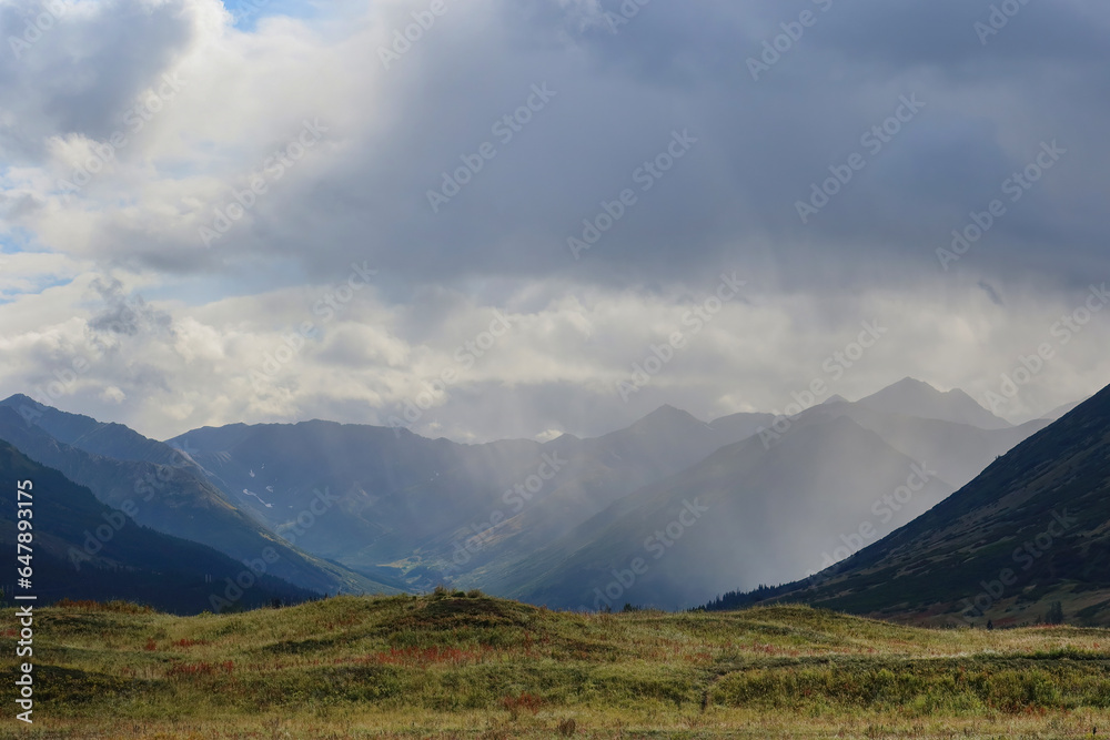 Rain clouds over a glacial valley and mountains in Alaska.