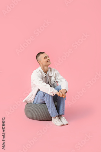 Happy young man sitting on ...