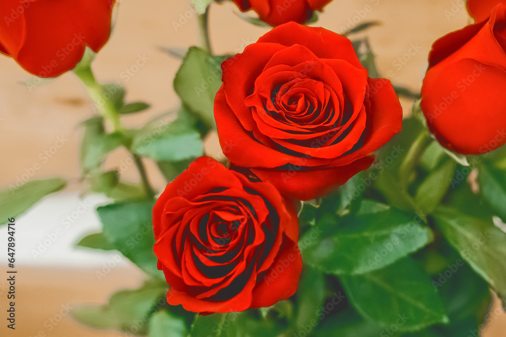 Bouquet of red rose flowers with green leaves on a wooden background, close up Bouquet of red rose flowers with green leaves on a wooden background, close up