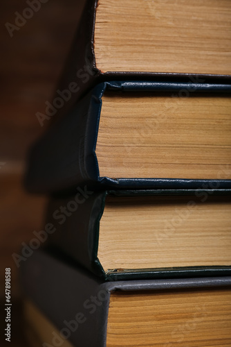 Stack of old hardcover books on wooden background  closeup