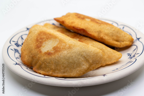 Front view Venezuelan empanadas stuffed with meat with beans and cheese on round plate on white background. selective focus. copy space