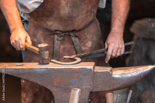 Blacksmith forging metal with tools