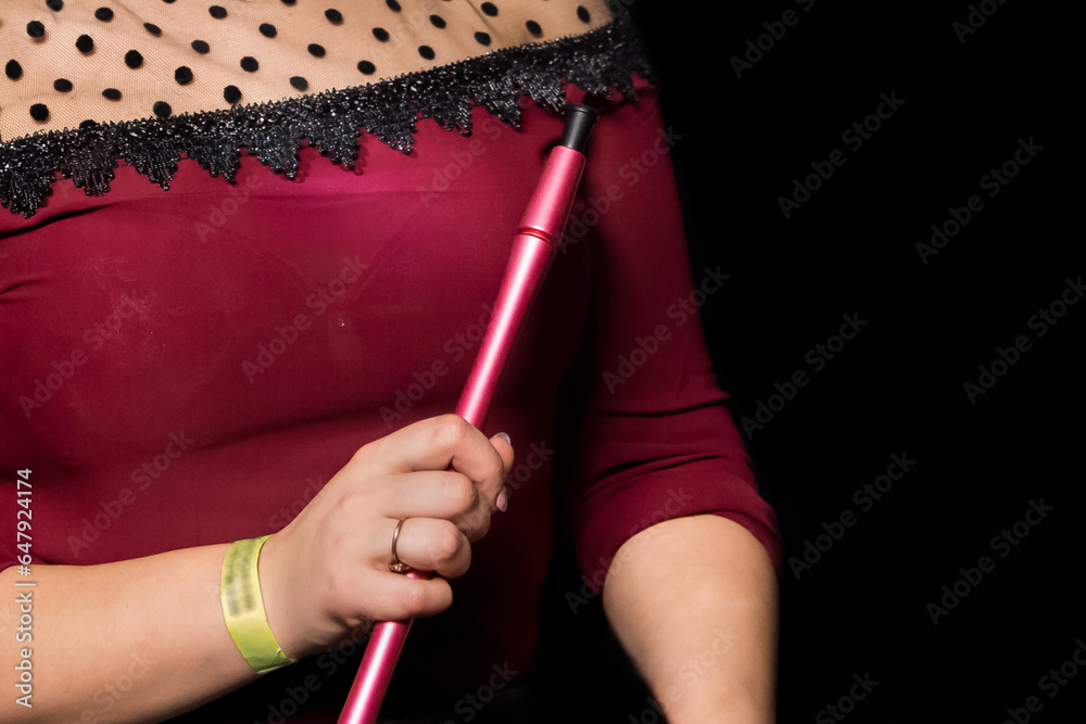A girl in a red dress holds a hookah pipe in her hand, a smoking object on a dark black background