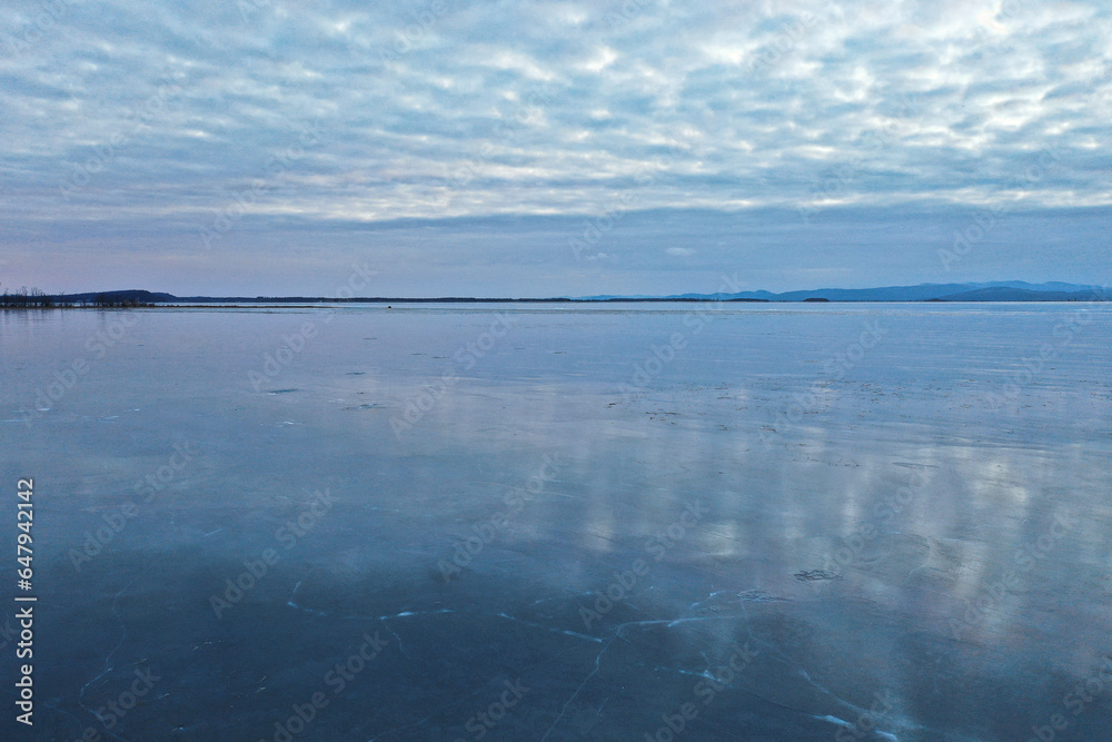 Dreamy aerial view of frozen Lake Champlain in the winter with reflective ice