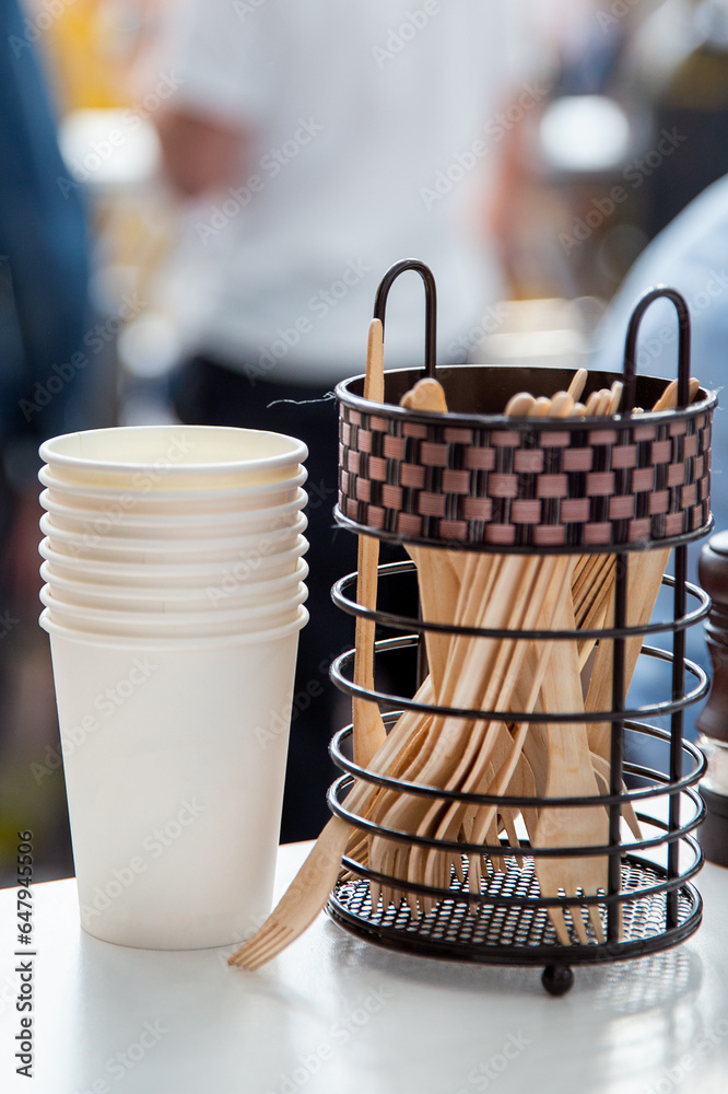 Obraz premium Stacked paper cups and set of wooden forks on table for tomorrow or lunch in a cafe