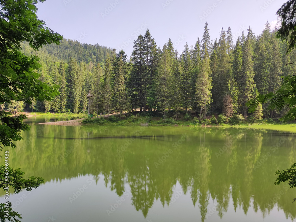 The water surface of the lake against the backdrop of a hilly forest
