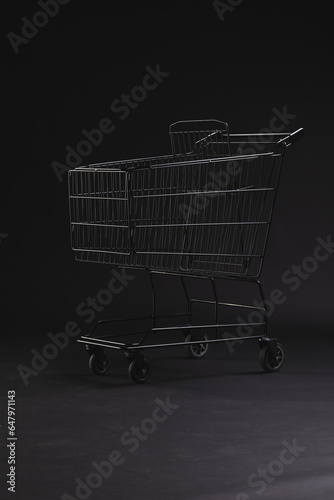 Vertical image of shopping trolley with copy space over black background