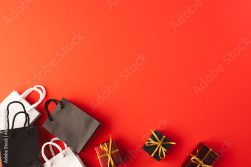 Gift boxes with ribbon, gift bags with copy space over red background