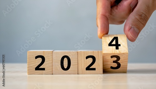 hand holding a sign of success wallpaper wooden cube with the years '2023' and '2024,' highlighting the preparation.