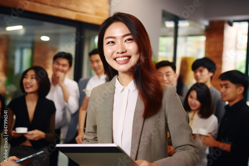 Woman holding tablet in front of group of people. This versatile image can be used to represent technology, communication, teamwork, or business meetings.