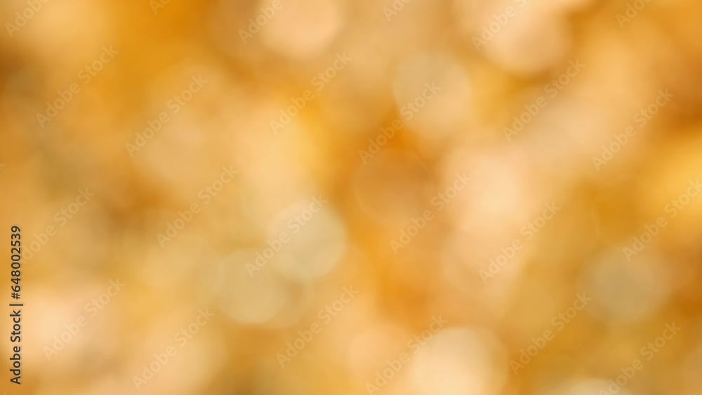Shimmering blurred golden bokeh background in slow motion. Beautiful festive golden background. Shimmering blurred golden bokeh background in slow motion. Beautiful festive golden background.