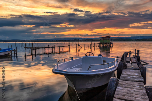 Stunning sunset at sea shore with boat at jetty