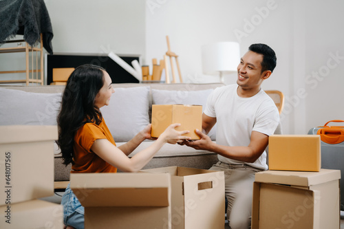 Happy asian young attractive couple man and woman with big boxes moving into a new house, new apartment for couple the new home, Moving house. © Nuttapong punna