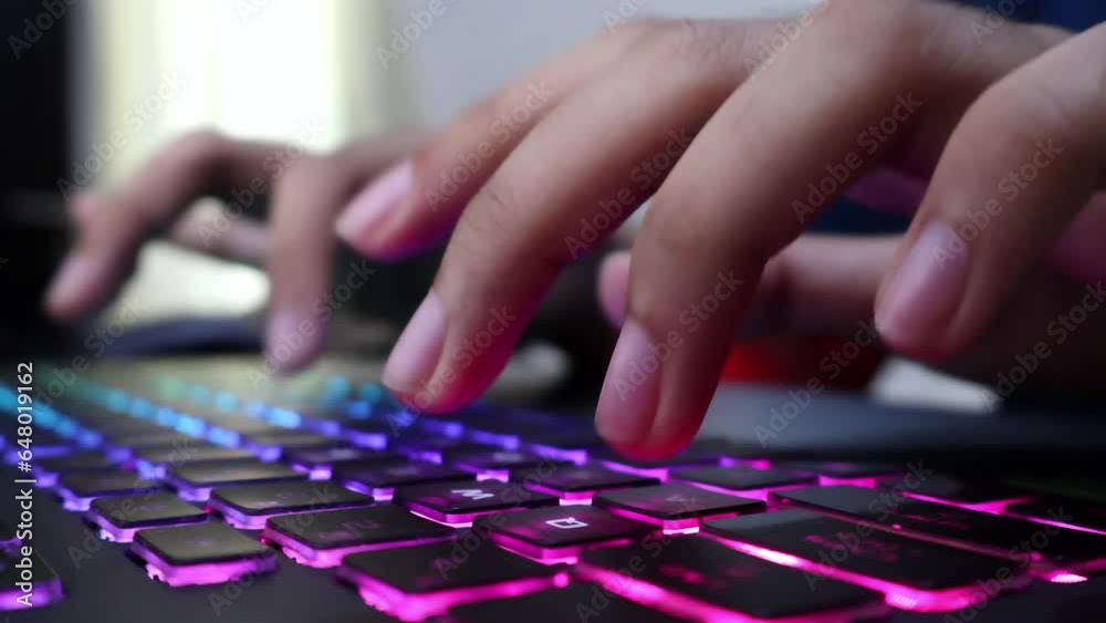 Closeup view of male hands typing on a gaming laptop keyboard with RGB backlit. Journalist writing article, programming, coding, modern business, freelancing, browsing, gaming, writing email. Closeup view of male hands typing on a gaming laptop keyboard with RGB backlit. Journalist writing article, programming, coding, modern business, freelancing, browsing, gaming, writing email.