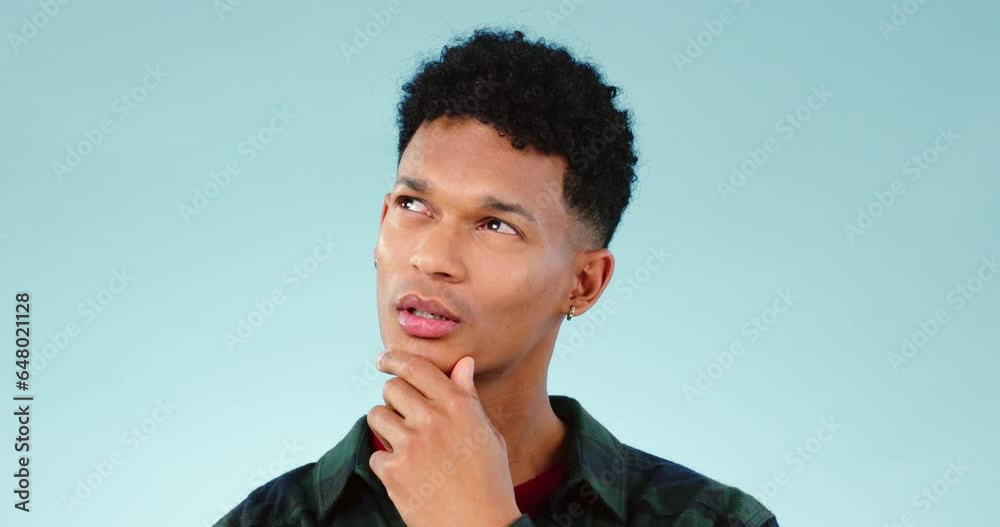 Thinking, idea and young man in a studio with dreaming, guess or question facial expression. Remember, reflection and model from Mexico with curious, solution or brainstorming face by blue background