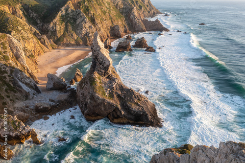 Portugal Ursa Beach at atlantic coast of Atlantic Ocean with rocks and sunset sun waves and foam at sand of coastline picturesque landscape panorama.
Praia da Ursa beach at Sintra-Cascais Natural Park photo