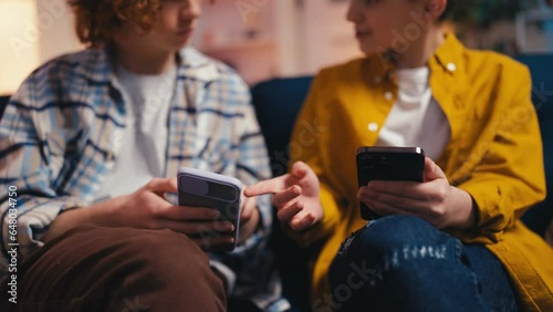 Closeup of teen guys using smartphones, discussing funny videos on social media photo