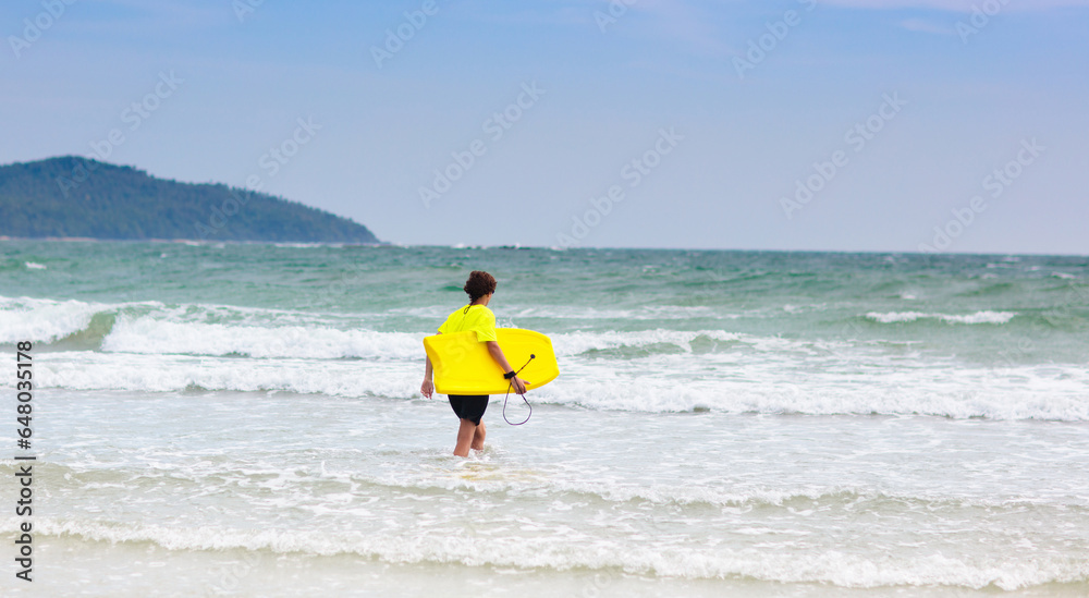 Surfer on tropical beach. Boy surfing. Surfer on tropical beach. Boy surfing.